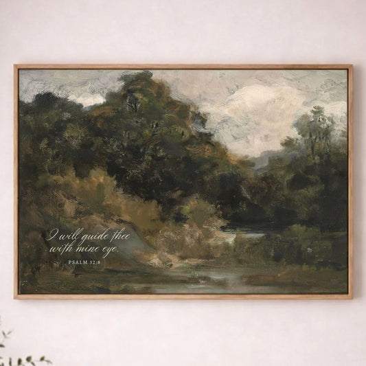a painting of a serene landscape with a forest and a body of water, hanging on a wall above a wooden table.