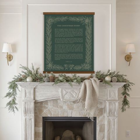 a fireplace mantel decorated with greenery, pine cones, and ornaments, with a framed inspirational quote displayed above it.